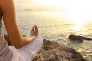 women meditating by sea